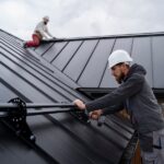 a man in hardhats holding a drill on a roof